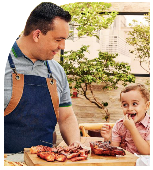 Pai e filho comendo churrasco de linguiça e peça de carne